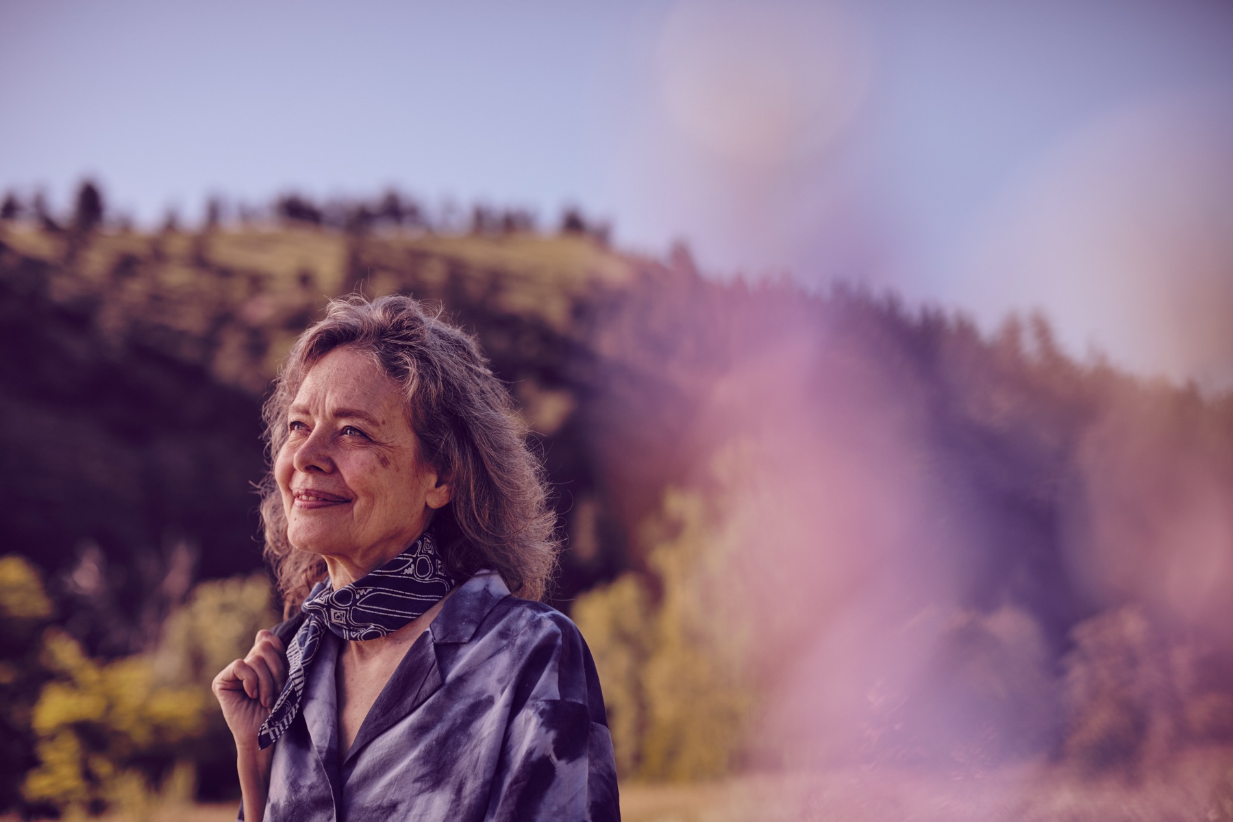 Connirae outdoors at golden hour, hills and sky behind